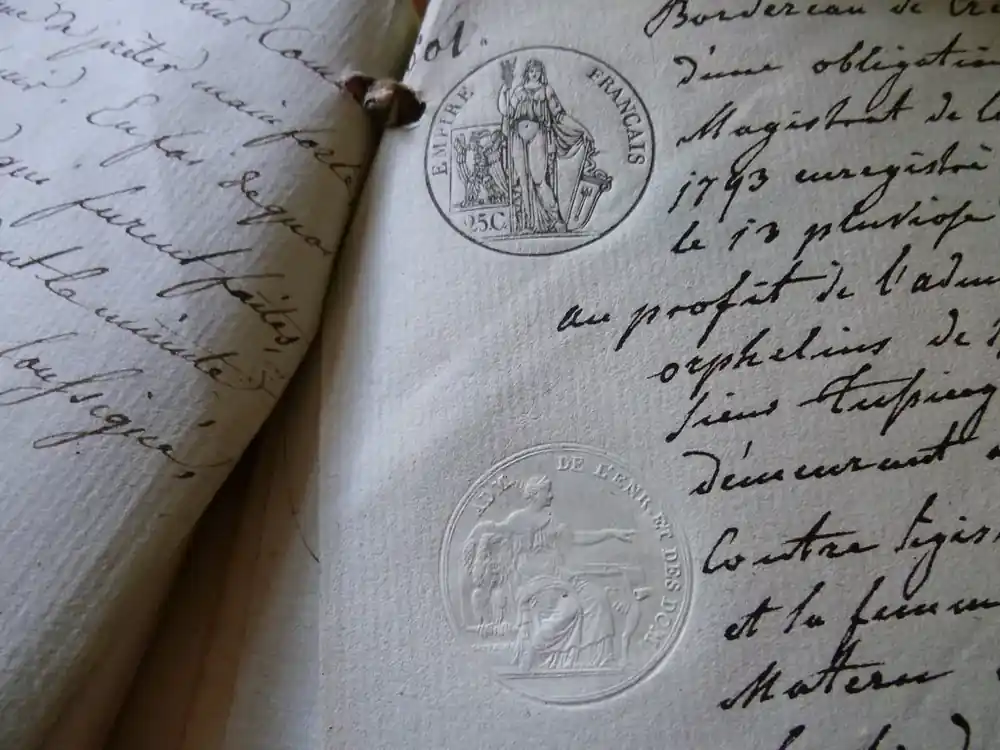 Close view of a handwritten old document with an embossed paper stamp